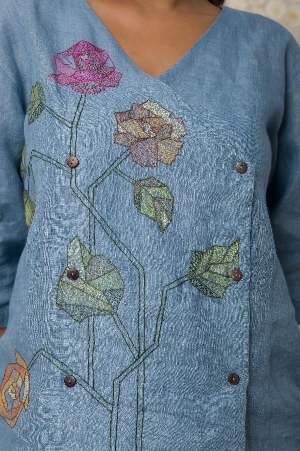 Powder blue floral appliqué V-neck top, embroidery close-up