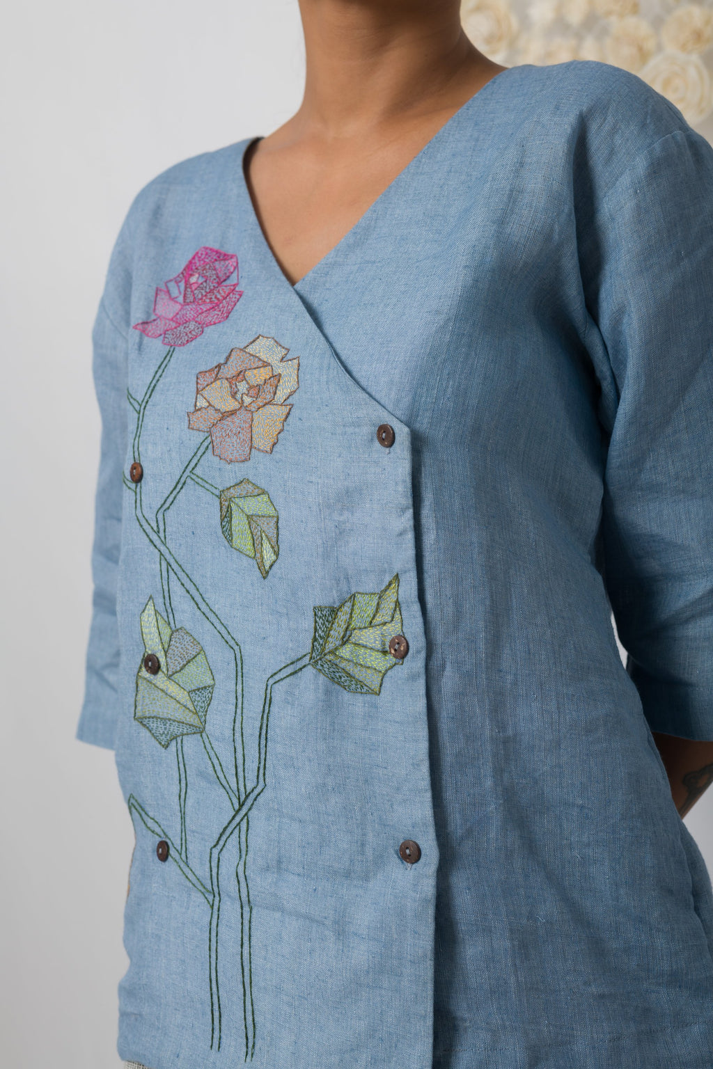 Powder blue floral appliqué V-neck top, side-button wrap detail