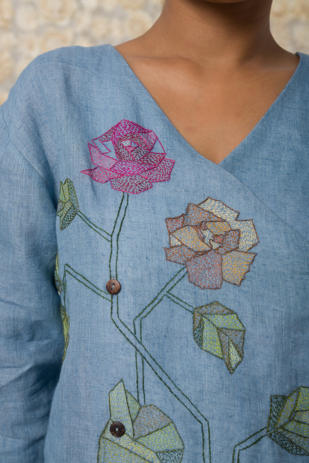 Powder blue floral appliqué V-neck top, rose embroidery close-up